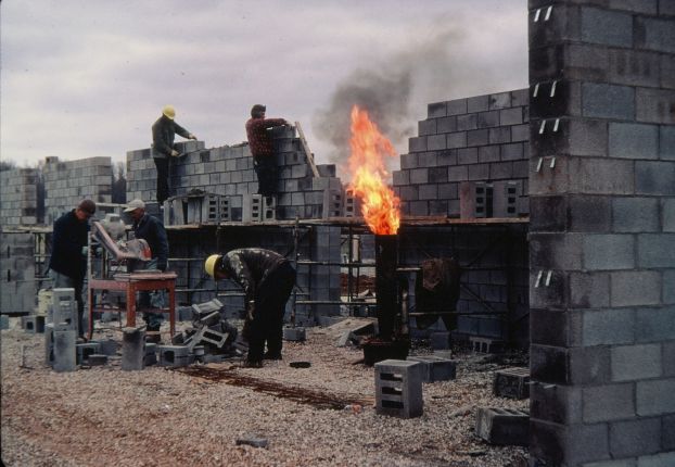 Men building a concrete block wall.
