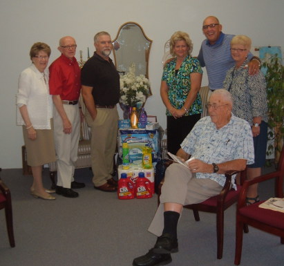 Becomers adult Bible study class with household supplies they are donating to a needy local family.