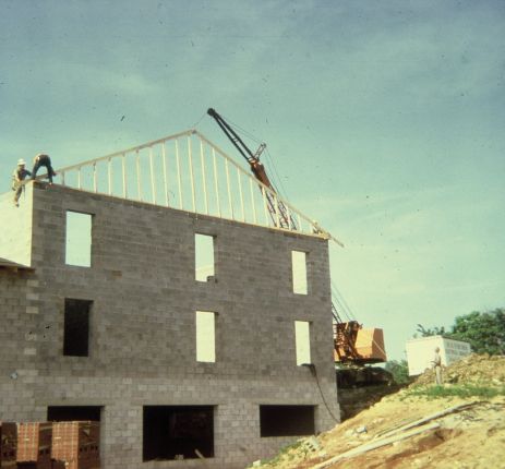 Wooden truss added to a three-story concrete block structure.