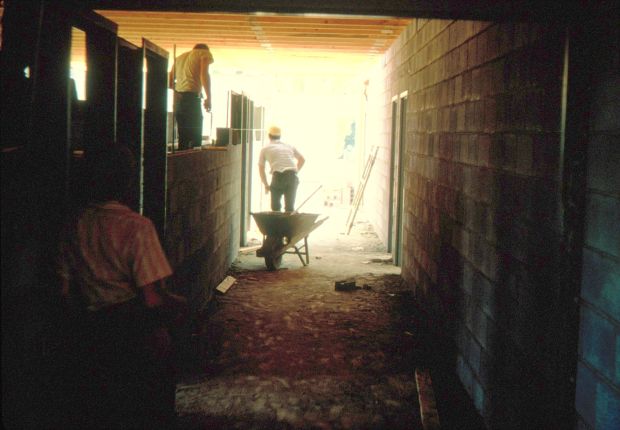 Men doing construction work inside a building.