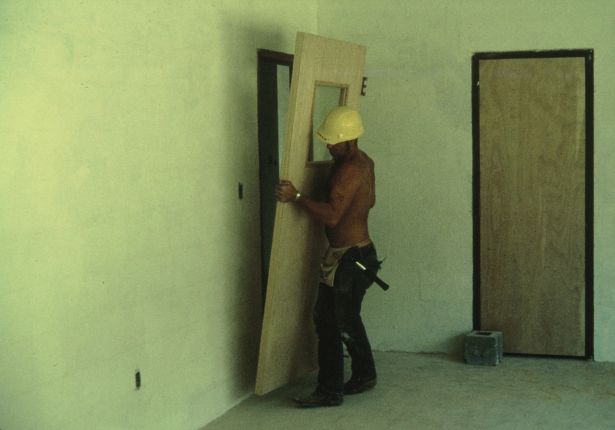 Man installing a wooden door.