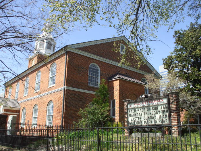 Rear of the Old Otterbein Church and its sign announcing Palm Sunday and Easter services.