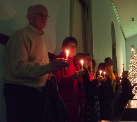 Members of the Paoli United Methodist Church hold candles and sing during a candlelight Christmas Eve service.