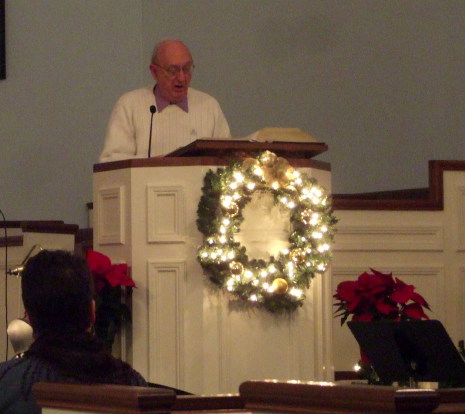 Howard Detweiler sings during a candlelight Christmas Eve service.